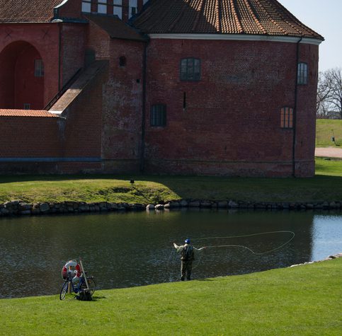 Landskrona, Sweden- May 1, 2013: Fisherman engaged in fly fishing on the  500 years old water that is  surrounding Citadel-fort from 1549. Fly fishing is a very popular sport in Sweden.